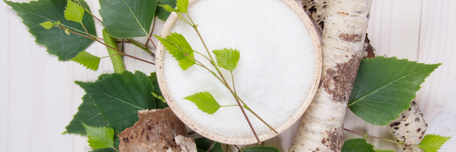 zuckeralternative in einer Schale zwischen Blättern und Ästen. Auf weißem Hintergrund